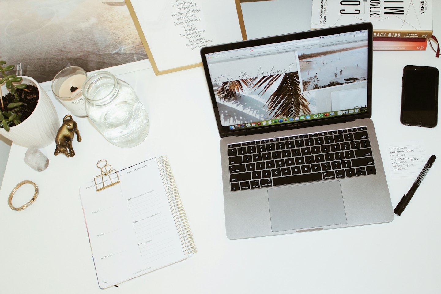 Laptop and office supplies arranged on a clean white desk.